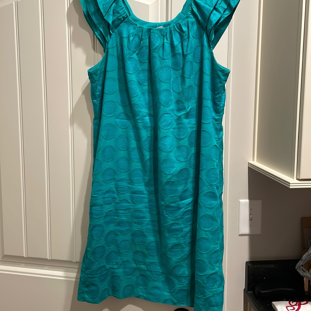 Above knee length; fully lined. Gathered round neck.